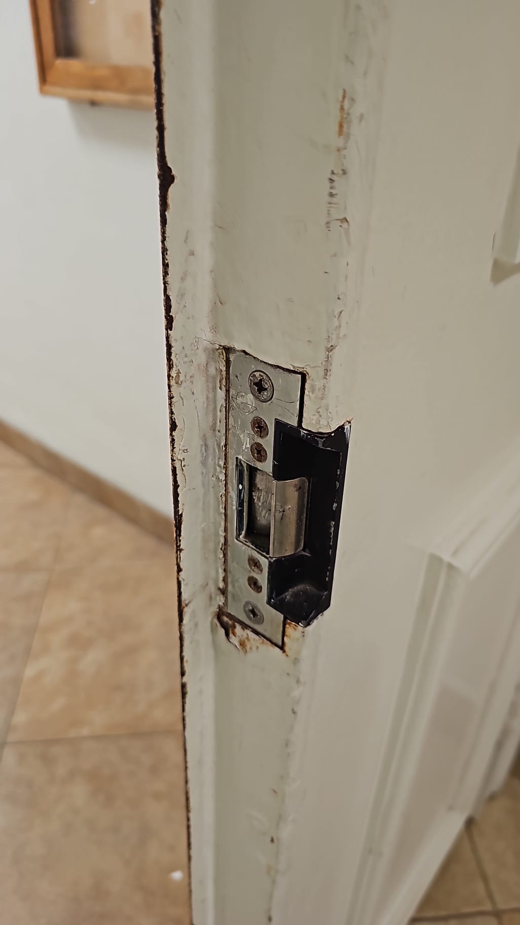 Close view of the worn commercial door lock and edge hardware