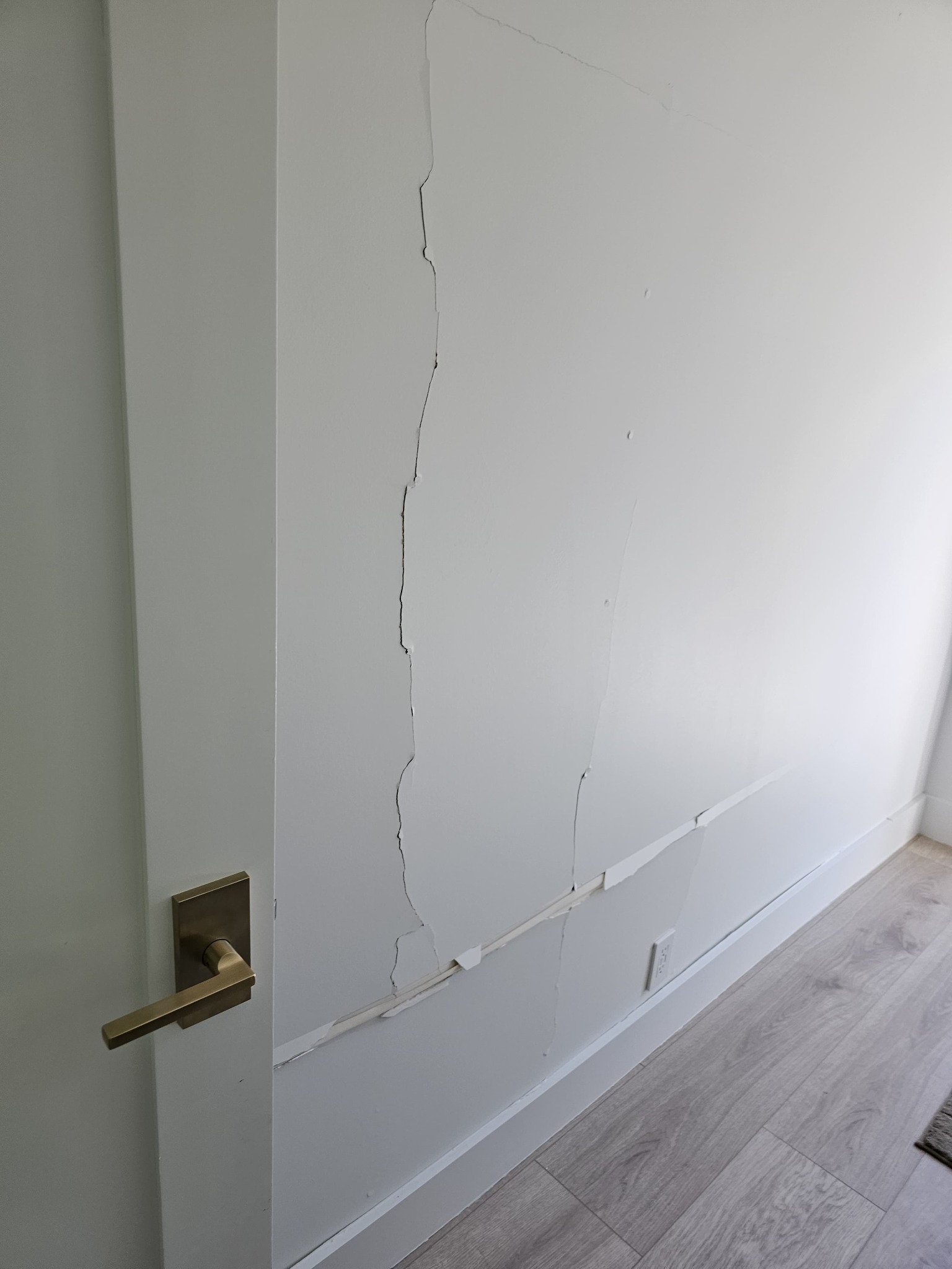 Cracked drywall visible from the interior side of the garage wall