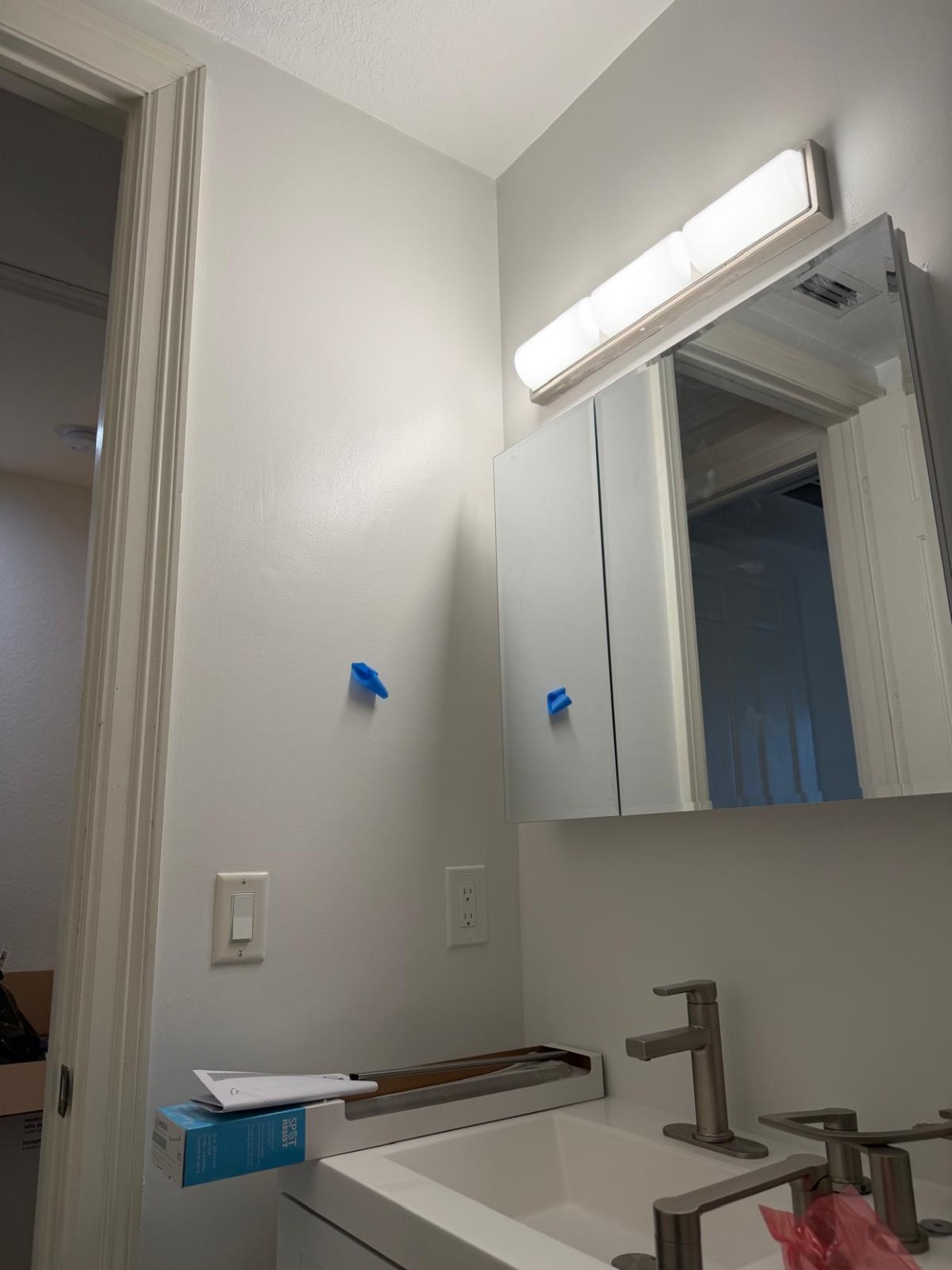 New bathroom mirror, vanity light, faucet, and wall finish